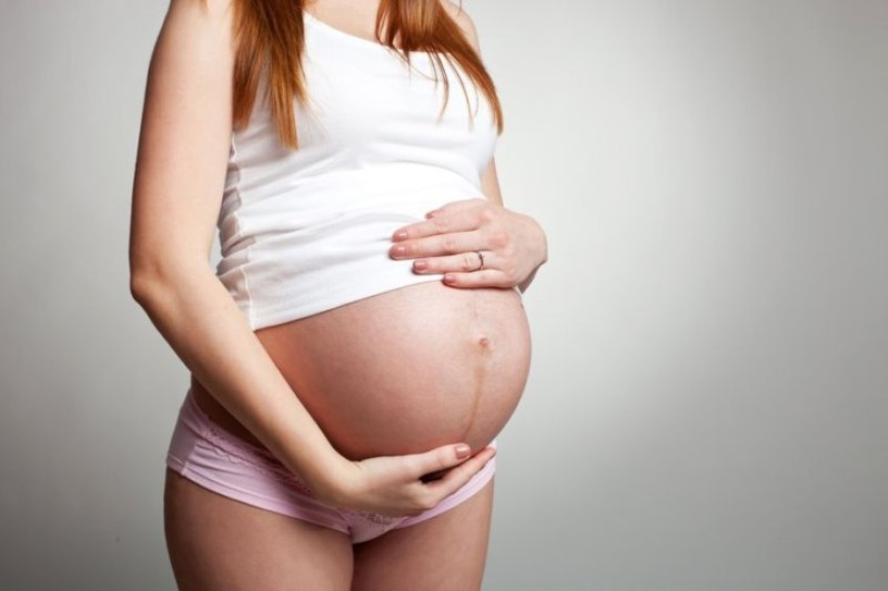 Беременная женщина держится за живот